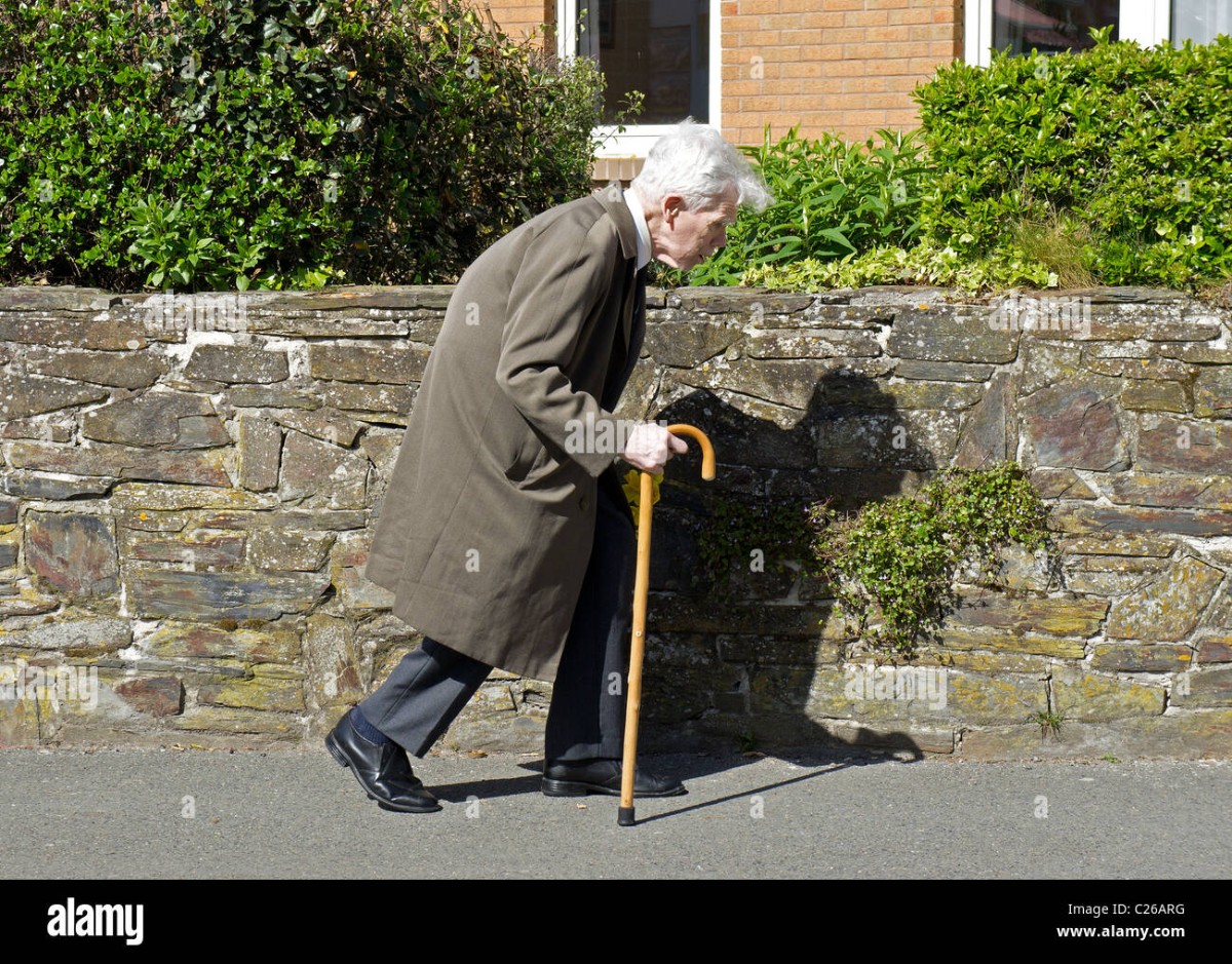 an-old-man-using-a-walking-stick-C26ARG.jpg